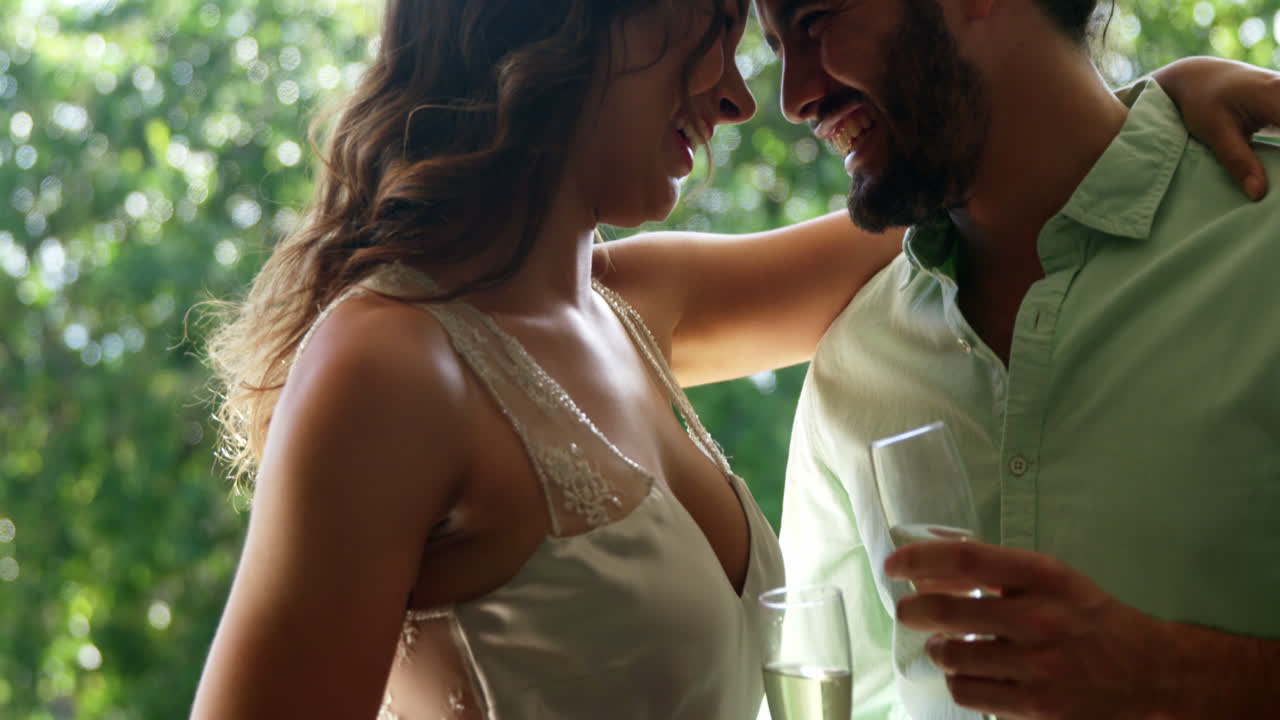 pareja mirando cara a cara y sosteniendo flautas de champán en el restaurante