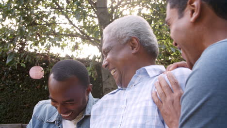 black dad and two adult sons laughing together in garden