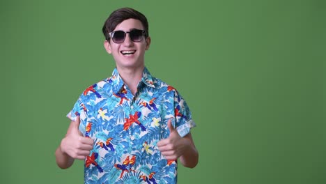 young handsome iranian teenage boy ready for vacation against green background