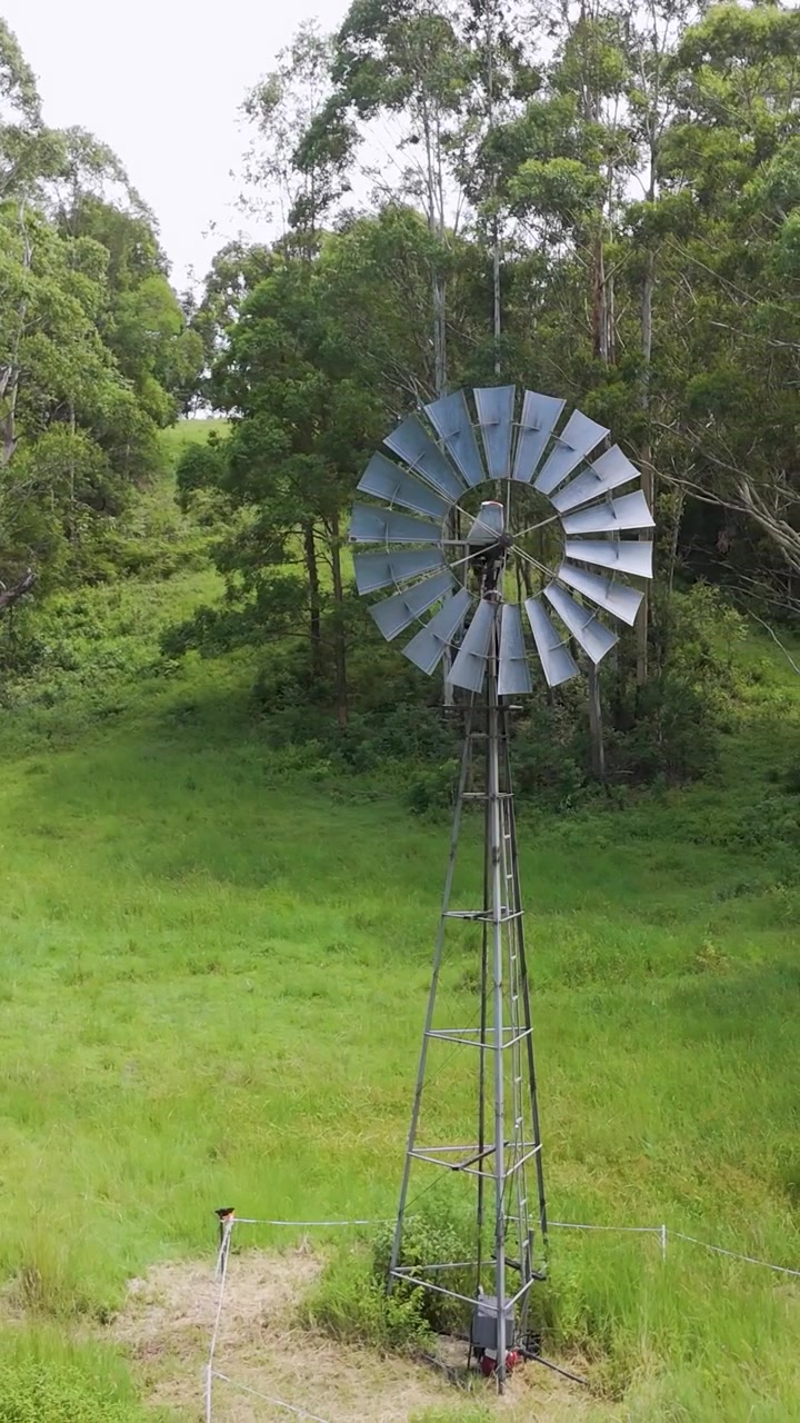 Windmill in lush green farm landscape