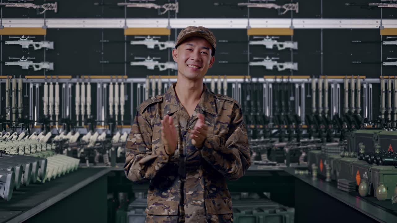 アジア系の兵士の男性が、武器庫で笑顔で手を叩いています。
