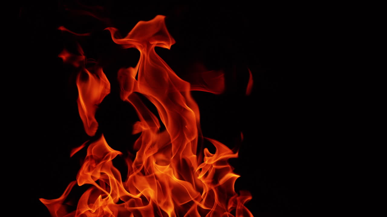 Red hot flames of campfire in the darkness. Upper part of bonfire isolated at black backdrop.