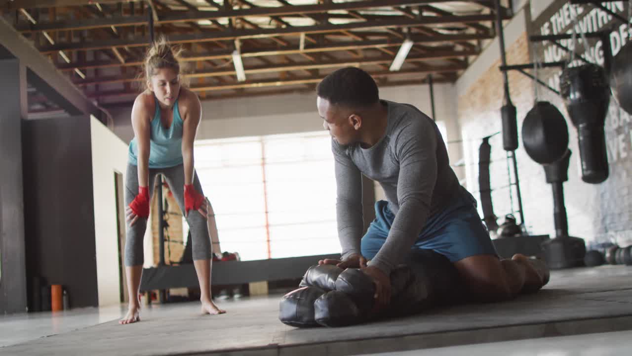 video de una mujer y un hombre en forma preparándose para entrenar en el gimnasio