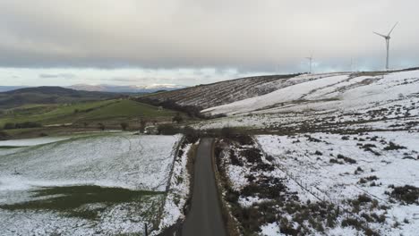 snowy rural winter valley countryside aerial agricultural farmland highlands rising pull back