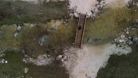 Hombre-En-Un-Puente-De-Madera-Sobre-Un-Río