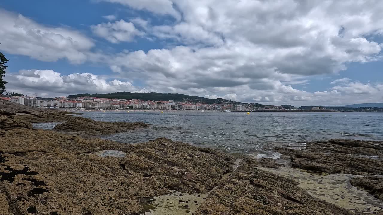 dietro la scogliera un piccolo e lussuoso villaggio di vacanze di appartamenti costosi sulla costa atlantica un giorno con mare calmo e nuvole basse spettacolari, colpo panoramico bloccato