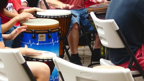 children's hands play hand drums in a drum circle