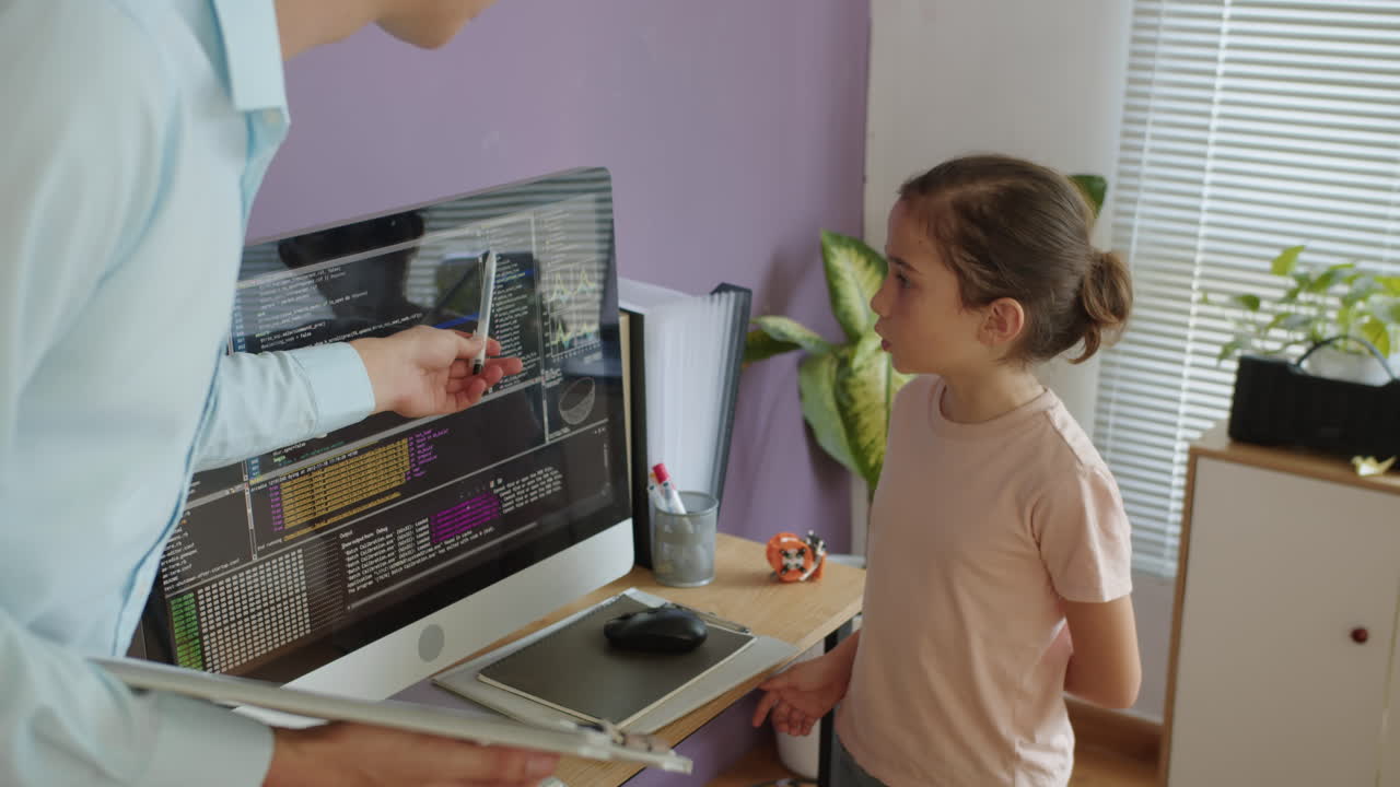 Schoolgirl Reading Coding Script on Monitor at IT Class