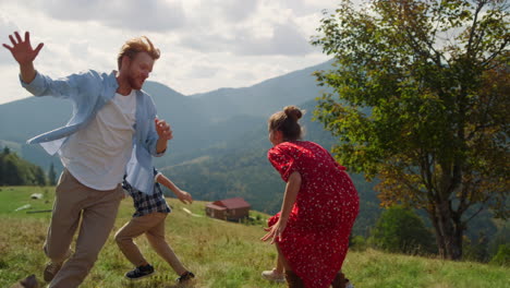 Familie-Läuft-Berghang-Sonniger-Tag.-Eltern-Spielen-Aufholjagd-Mit-Kindern.