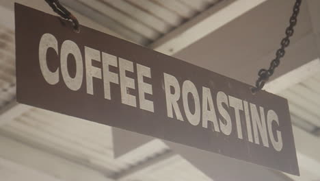 coffee roasting sign hangs from chain on ceiling