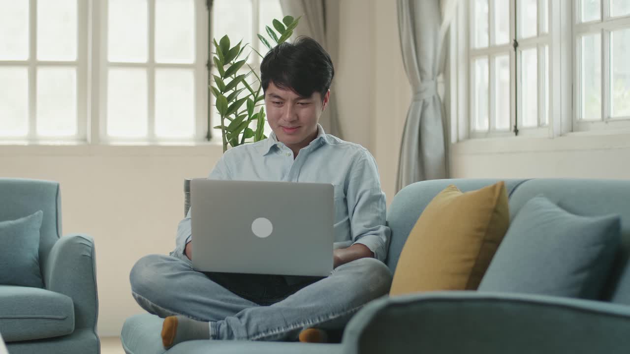 Man Sitting Sofa And Use Laptop Computer In Living Room, Video In 4K