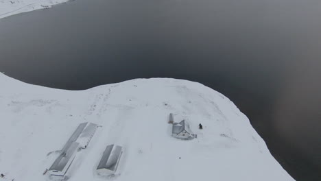 View-from-above-at-farm-covered-in-snow,-winter-Iceland