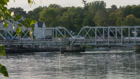 stationary medium-tight shot of cars driving across a bridge, light traffic