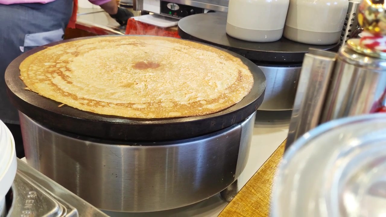 Venditore di street food che prepara una crepe fresca