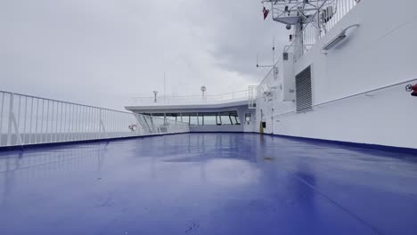 covers a car ferry on the sea in light winds and a cloudy sky with the captain's steering bridge