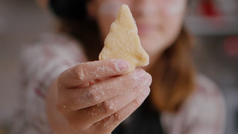 selective focus of child holding cookie dough with tree shape in hands