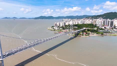 vista aérea del puente hercilio luz en florianópolis, brasil, que muestra playas, paisajes urbanos y el horizonte oceánico