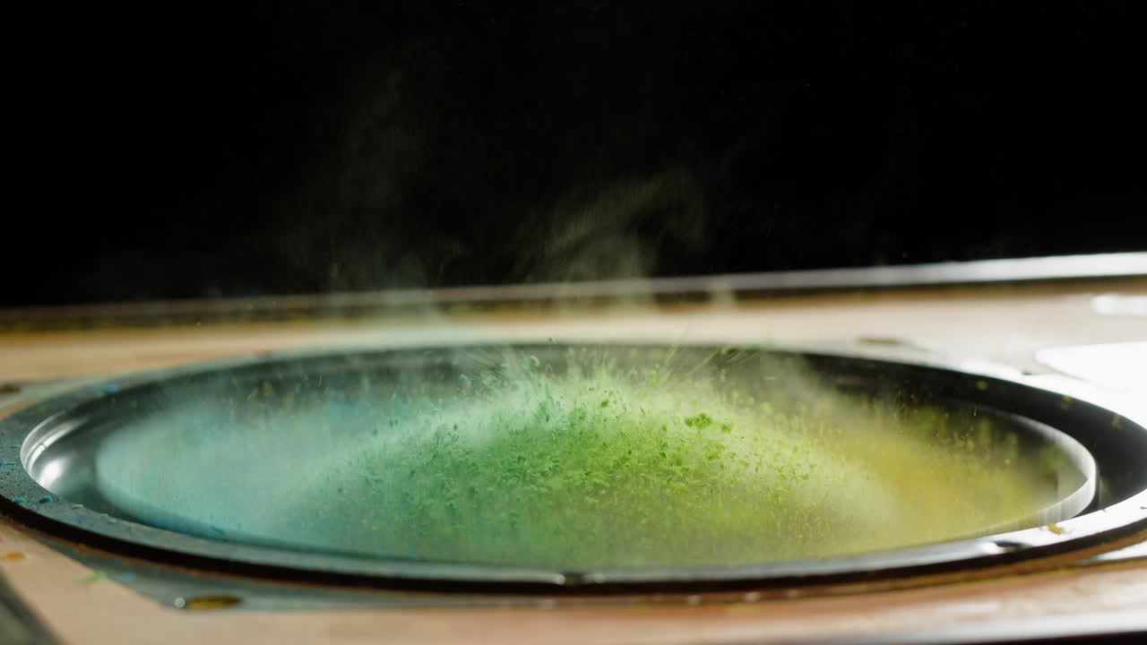 Polvere Holi vibrante che danza sulla membrana dell'altoparlante