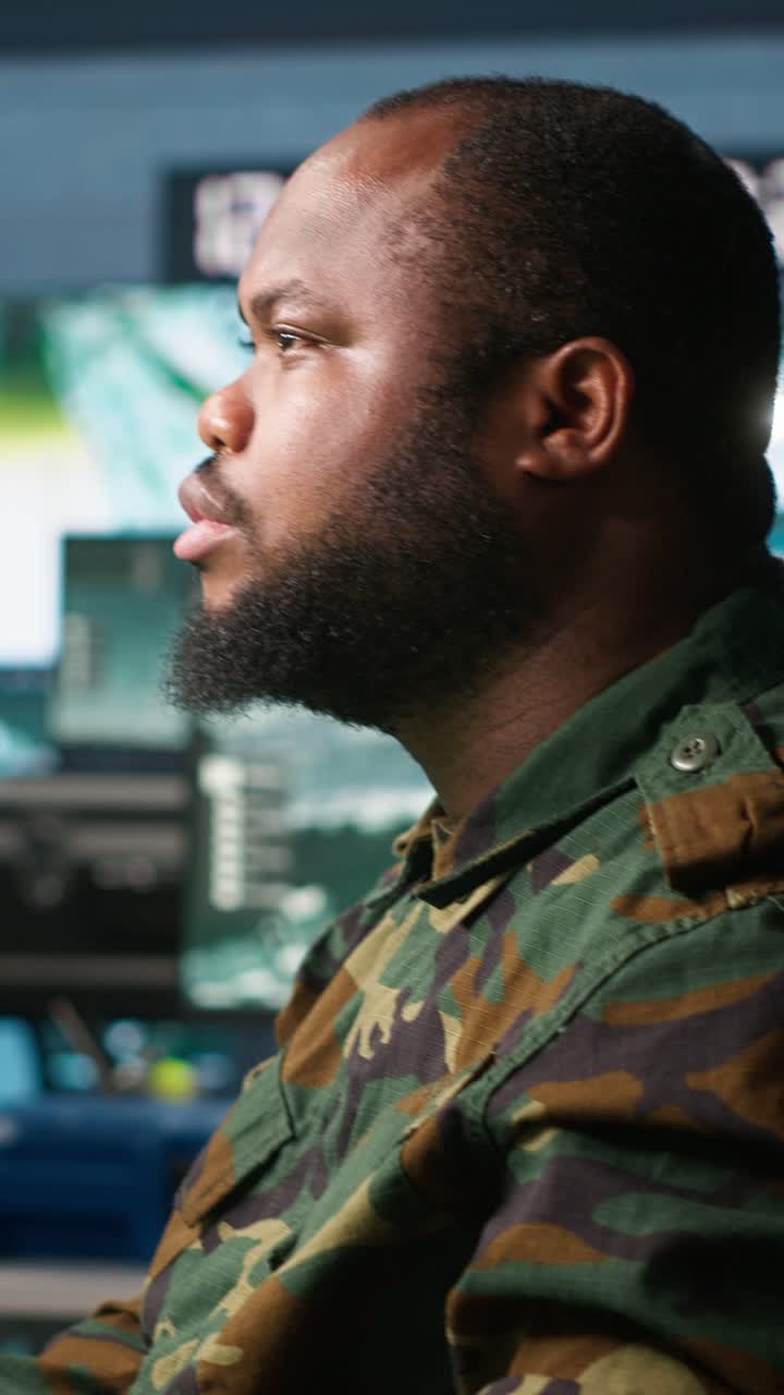 Vertical video Man monitoring army HQ CCTV for any unauthorize activity