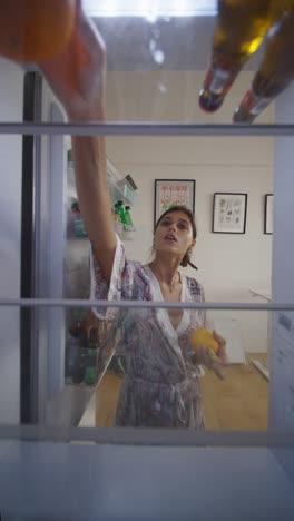 woman getting food from refrigerator