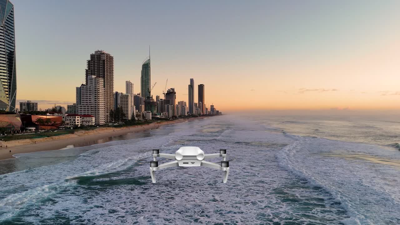 A drone smoothly flies over ocean waves towards a city skyline during a vibrant sunset, capturing serene coastal beauty