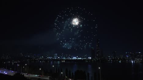 firework display exploding above han river with view of yeouido 63 building skyscraper during seoul international firework festival 2024