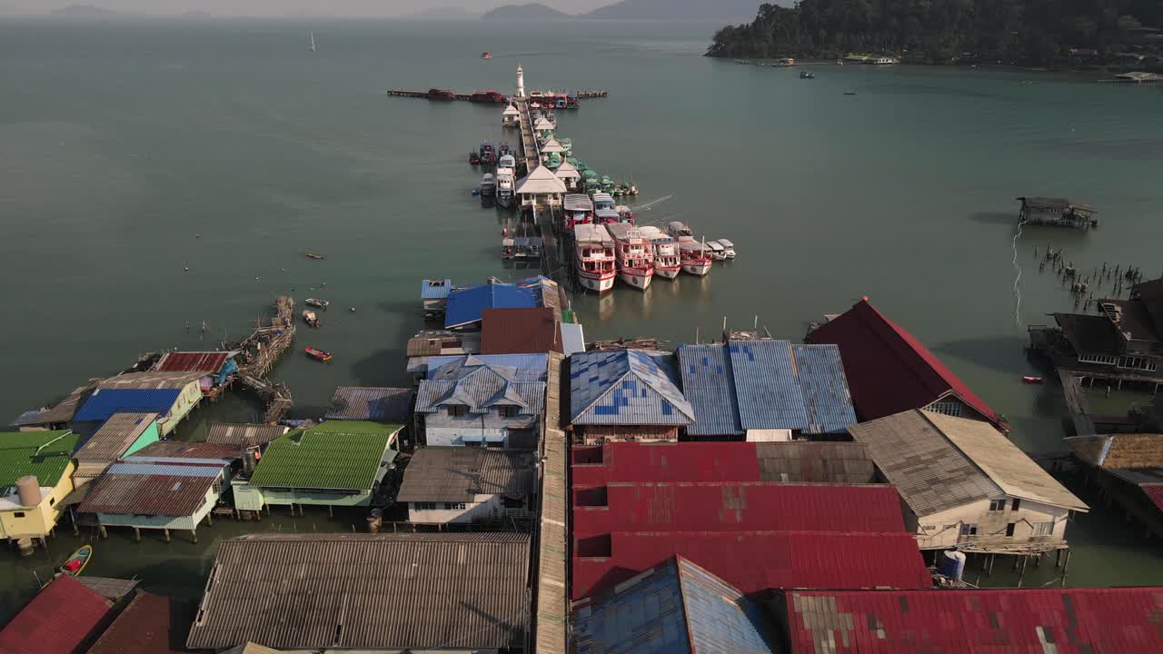 tiro giratorio de órbita inversa rápida sobre estructuras y barcos a lo largo del muelle bang bao en koh chang, tailandia