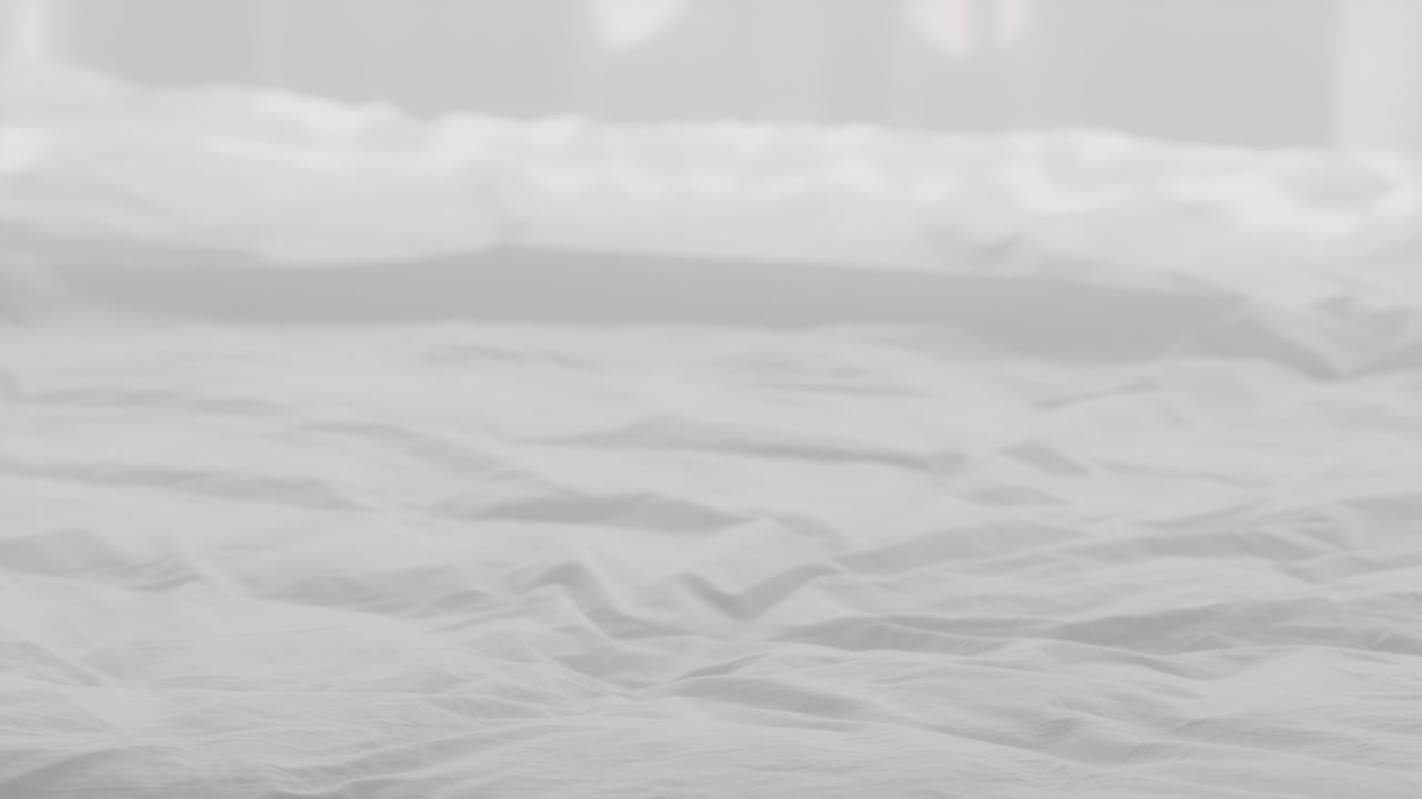 las manos de la mujer plegando toallas blancas limpias en una cama