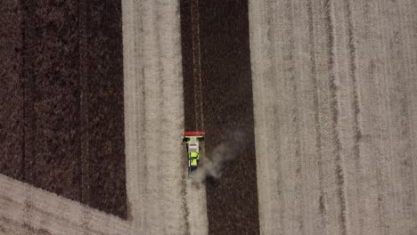 stationary aerial footage of a combine harvester harvesting feed beans