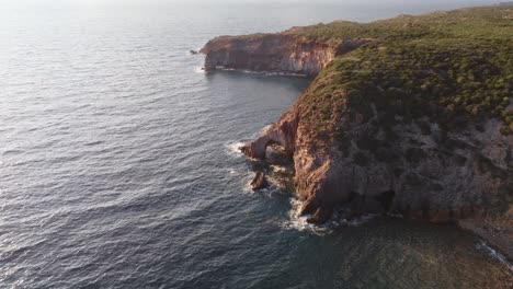 paradisiac remote cliff coast, with arched cave in south sardinia, aerial view