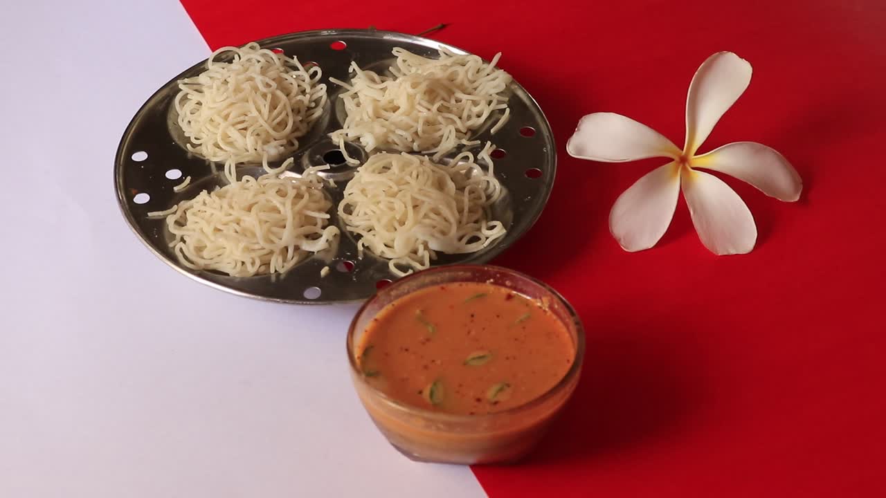 Idiyappam- String Hoppers -Traditional Kerala Steamed Breakfast on white and red background
