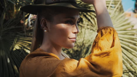 stylish young woman wearing a hat outdoors.