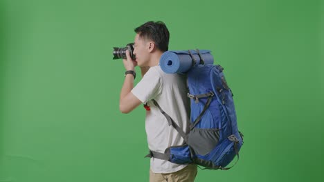 man with backpack and camera on green screen