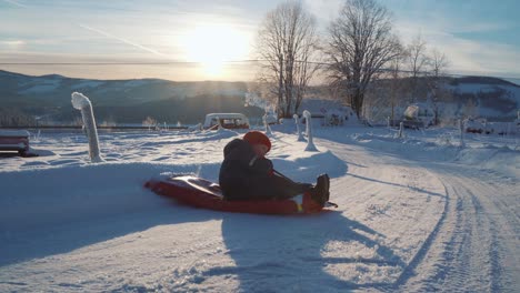 a boy is sledding in the snow during christmas and a beautiful sunset in norway