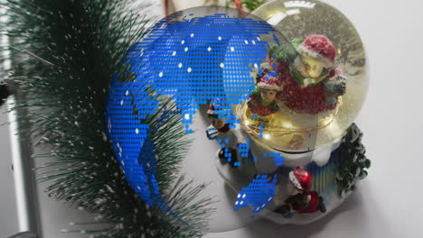 Snow globe with festive figures over digital blue globe animation