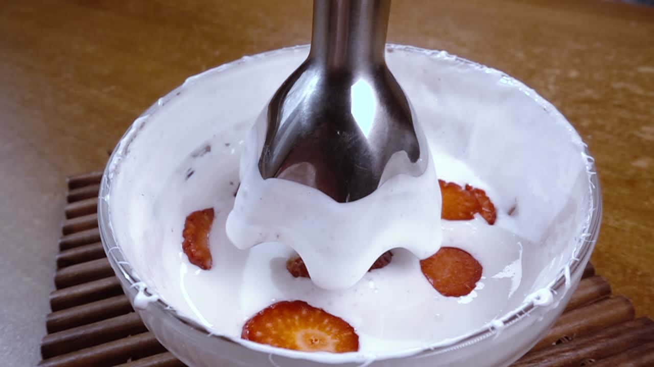huevos batidos con azúcar y fresas usando un mezclador. cámara lenta con disparo de seguimiento de rotación.