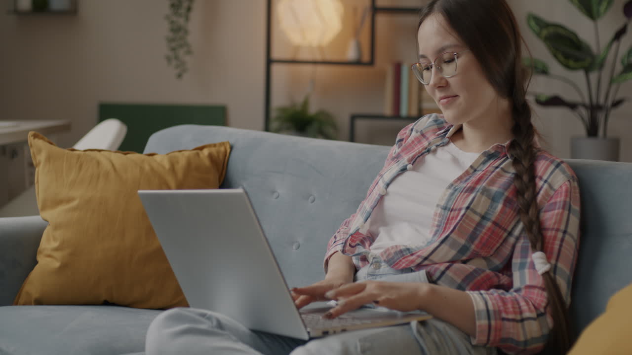 mujer joven trabajando en una computadora portátil en casa