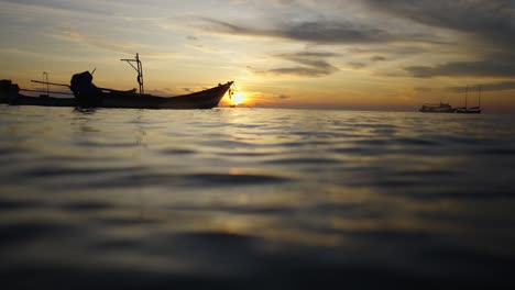 a boat silhouetted against a beautiful sunset over the ocean