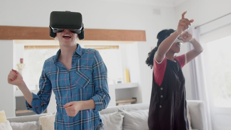 Amiche adolescenti felici e di diverse origini che giocano e indossano visori VR a casa, in slow motion