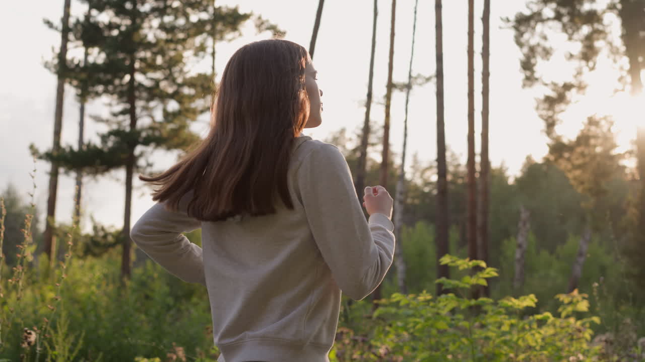 joven atleta corre en el bosque claro al atardecer. entrenamiento de cardio de construcción muscular con vistas a la luz del sol y los árboles en la naturaleza. campo y fitness solo