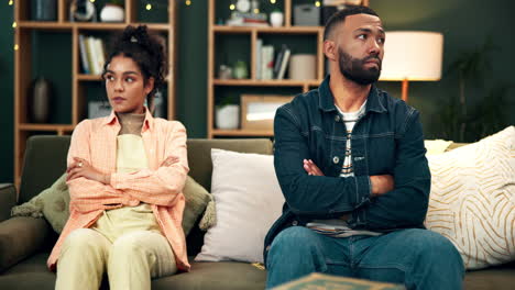couple in conflict sitting on a couch at home