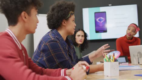 Happy-diverse-business-people-discussing-work-during-meeting-at-office