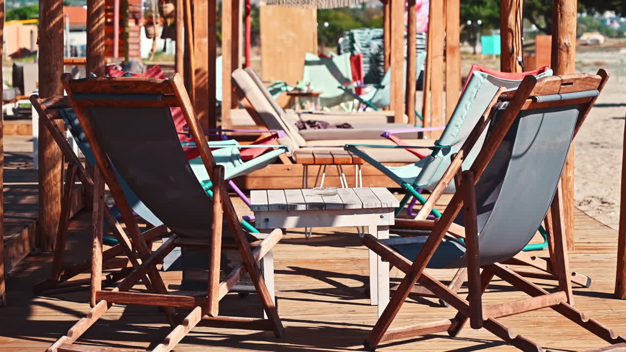 Beach on the aegean coast in Greece. Seats with table, sand