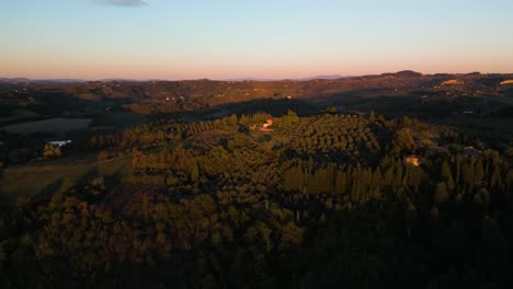 el resplandor de la hora dorada se extiende por la villa con vistas a los huertos de olivos toscanos.