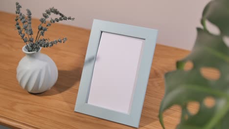 blank picture frame with lavender and plant on wooden table