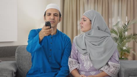 angry muslim couple fighting for tv remote