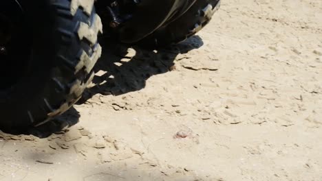 slow motion atv wheels spinning on the beach sand