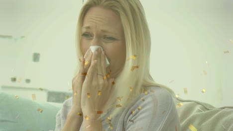 animation of golden confetti falling over caucasian sick woman with tissue blowing her nose at home