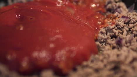 cocinar carne picada salsa boloñesa añadiendo salsa de tomate de cerca