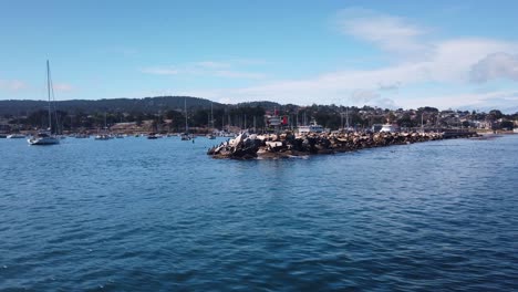 gimbal wide shot panning past the breakwater on a boat at the marina in monterey, california